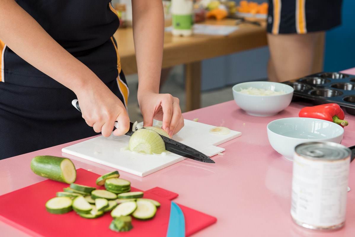 School girl cutting vegetables