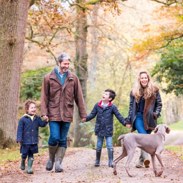 family of four walking with dog in Autumn