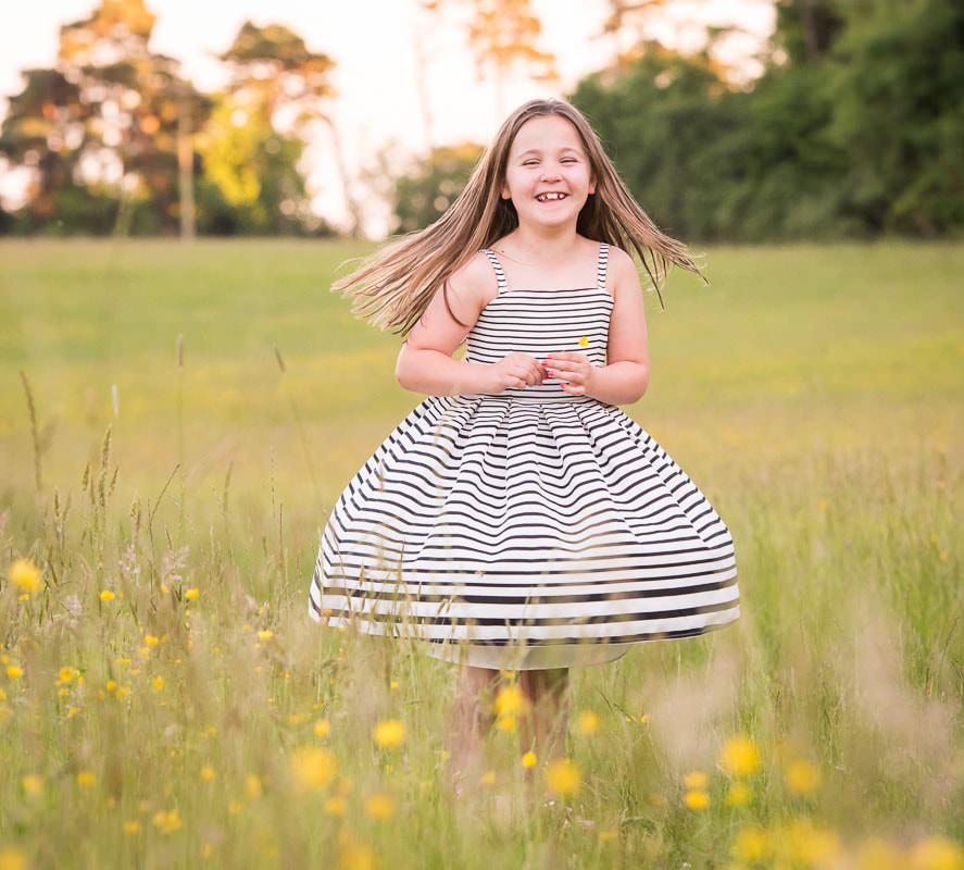 Young girl photographed in a buttercup meadow near Haywards Heath in Sussex