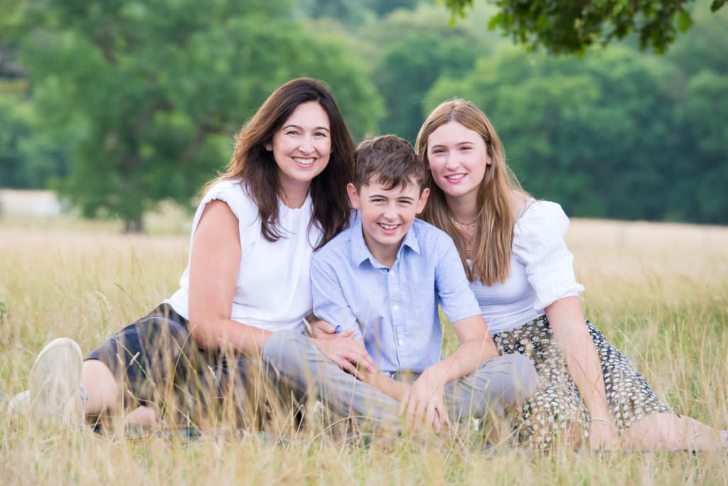 Mother and her children sitting in the grass during a Worth Abbey Family photoshoot